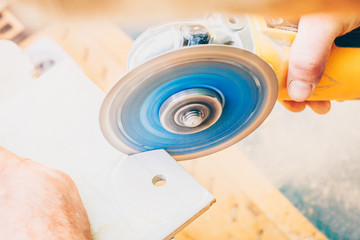 Wall Mural - Finishing works - the worker works with an angle grinder with his bare hands