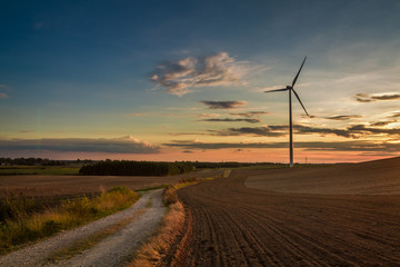 Canvas Print - Brown and blue sunset at countryside with wind turbine