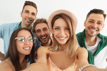 Canvas Print - Group of happy young people taking selfie on white background