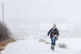 Fototapeta Tęcza - boy running home in snow storm