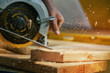 © ungvar - Circular Saw. Carpenter Using Circular Saw for wood beam