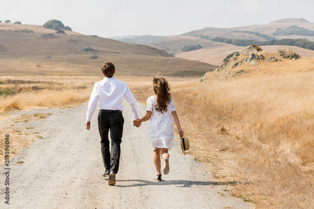 Love story. Couple holding hands and running away in mountains. Woman ...