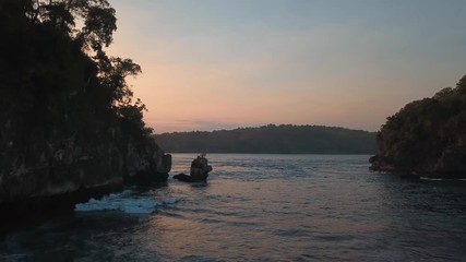 Wall Mural - sunset water with strong current, camera moving forward between rocks into the ocean