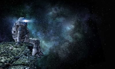 Wall Mural - spaceman on rock edge. mixed media
