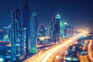 Scenic nighttime skyline of downtown Dubai, United Arab Emirates. Aerial view on highways and skyscrapers in the distance.