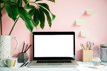 Wall Mural - Stylish and creative desk with laptop mock up screen, tropical leaf, office accessories and memo stick. Pink background wall. Design home office interior. 