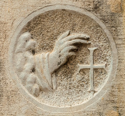 Wall Mural - Blessing hand with cross, an ancient religious relief on a Venice wall