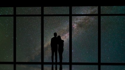 Wall Mural - The couple standing near windows on the meteor shower background. time lapse