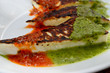 Grilled cheese with canarian sauces mojo rojo and mojo verde on a white plateclose up.Traditional tapas on Tenerife,Canary Islands,Spain.Selective focus.