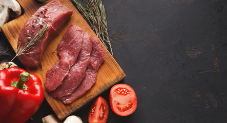 Raw beef filet mignon steaks on wooden board