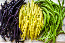 Collection Of Green, Yellow And Purple Bush Beans, Opened Green Peas On Wooden Background