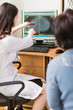 © Myroslava - The young breast specialist showing the ultrasound examination on a monitor to the patient in her office