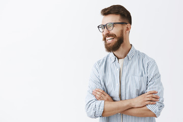 creative happy and funny bearded man with moustache in glasses with black rim turning left laughing 