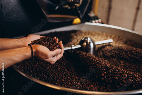 Plakaty do kawiarni freshly-roasted-coffee-beans-pouring-from-a-large-coffee-roaster-into-the-cooling-cylinder