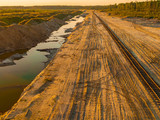 Fototapeta Do pokoju - Aerial view of huge, modern open pit mine. water, road. sunset.