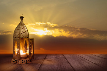 Wall Mural - festive oriental lantern on wooden planks in sunset for ramadan celebration greeting card