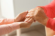 © New Africa - Helping hands on blurred background, closeup. Elderly care concept