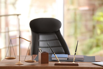 Table with scales of justice in lawyer's office