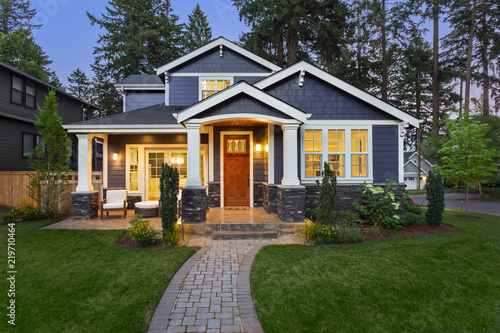 Fotografía Beautiful home exterior in evening with glowing interior lights and landscaping