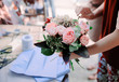 Woman is crafting rose flower bouquet on the wooden table