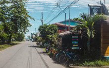 Street Lined With Bicycle Hire Shops And Cafes In The Popular Tourism Destination Of Puerto Viejo, On The Caribbean Side Of Costa Rica