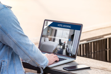 Wall Mural - a man is working using laptop, searching for lodging using on-line web service, booking a hotel on w