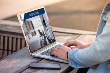 Wall Mural - a man is working using laptop, searching for lodging using on-line web service, booking a hotel on w