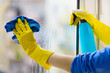canvas print picture - Gloved hand cleaning window rag and spray