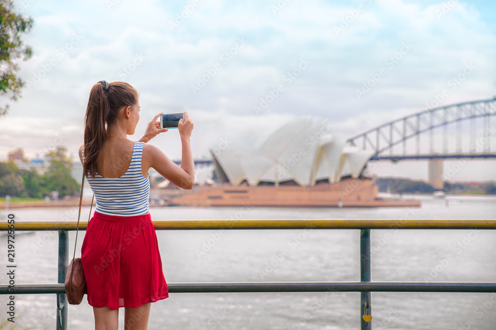 Sydney travel tourist woman taking phone picture of Opera house on Australia vacation. Asian girl using cellphone for photos during holiday. - obrazy, fototapety, plakaty 
