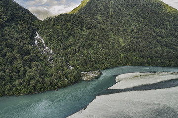 Wall Mural - New Zealand nature landscape aerial drone view of Haast River and Roaring Billy Falls waterfall in Mount Aspiring National Park, South Island, New Zealand.