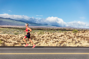 Wall Mural - Triathlon runner triathlete man running on road wearing tri suit at competition race. Sport athlete on marathon run exercising cardio in professional outfit. Fitness in Hawaii, USA.