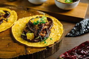 Foie Gras Tacos served on wooden chopping board with different sauces and Mexican dried chili.