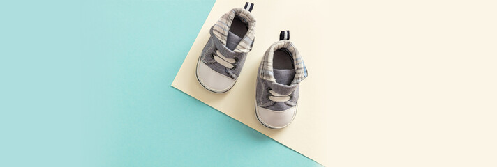 Wall Mural - Baby boy shoes on pastel colors background, banner