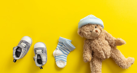 Wall Mural - Baby boy shoes and socks on bright yellow background