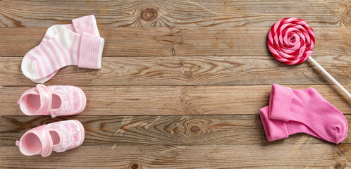 Wall Mural - Baby girl shoes and socks on wooden background