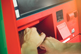 Fototapeta Niebo - Man hand entering PIN code on ATM machine keypad and cover it with other hand for security.