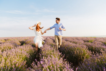 Wall Mural - Beautiful young couple embracing at the lavender field