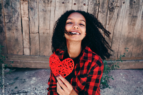 Fotografia, Obraz Preciosa chica joven sosteniendo en sus manos un corazón rojo