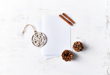 Canvas Print - An arrangement of Christmas decorations and blank paper cards on white wooden background. Flatlay. Copy space