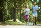 Fototapeta  - Active and healthy aged couple running in natural environment on summer morning