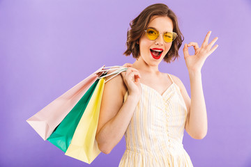 Wall Mural - Woman isolated over purple wall showing okay gesture.