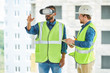 © Seventyfour - Waist up portrait of two modern construction workers using VR gear to visualize projects  on site, copy space