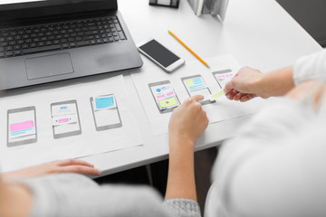 app design, technology and business concept - web designers or developers with laptop computer and s