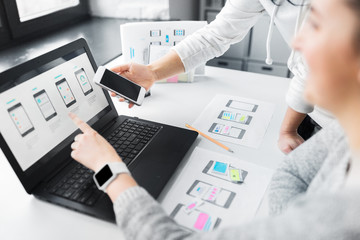 Wall Mural - app design, technology and business concept - web designers or developers with laptop computer and s