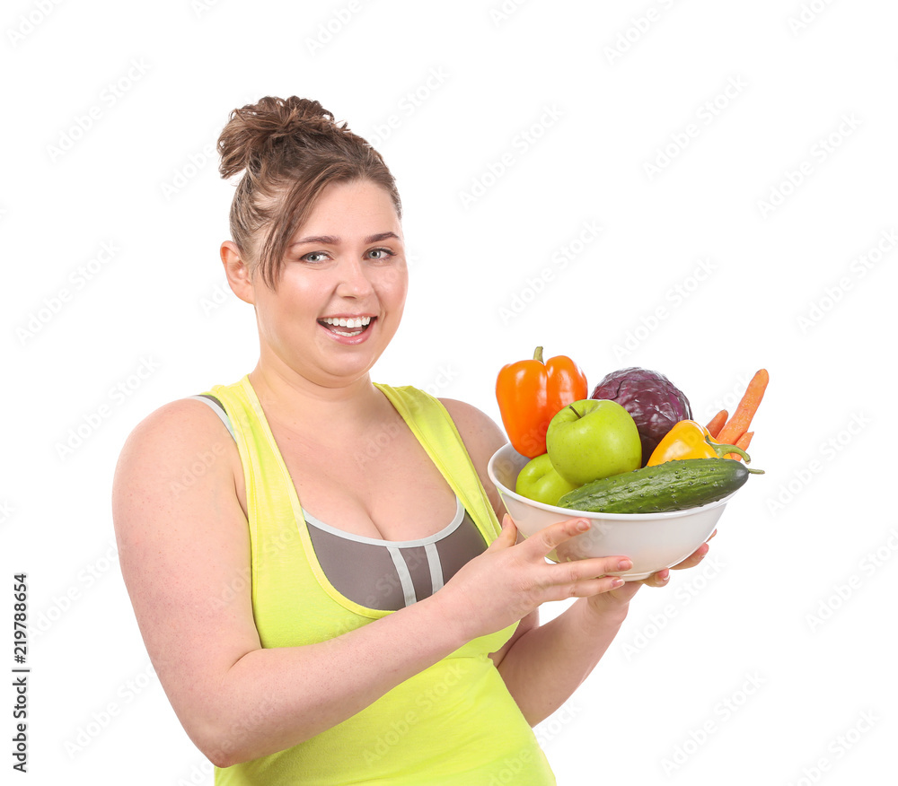 Young stout woman holding bowl with vegetables on white background. Diet food concept