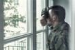 © Photographee.eu - Depressed and sad soldier in green uniform with trauma after war standing near the window