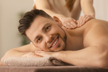 Wall Mural - Young man receiving massage at spa salon