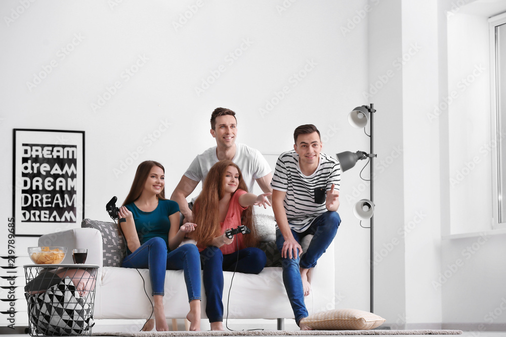 Young people playing video games at home