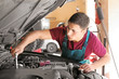 © Pixel-Shot - Young auto mechanic repairing car in service center