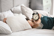 © Pixel-Shot - Morning of beautiful woman with alarm clock lying in bed